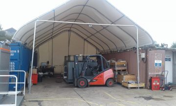 a canopy fixed to two shipping containers to create a covered workshop