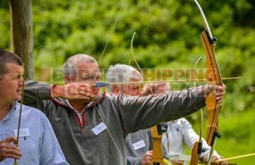 One person in a group takign aim with his bow and arrow