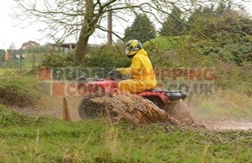 Quad bike spashing through a muddy puddle
