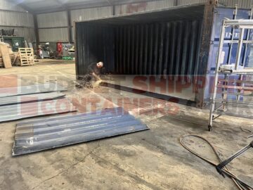 man working on removing side of 20' used container