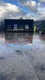 shipping container with the side removed for pallet storage