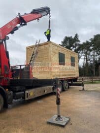 driver attaching chains ready to offload shipping container from hiab truck