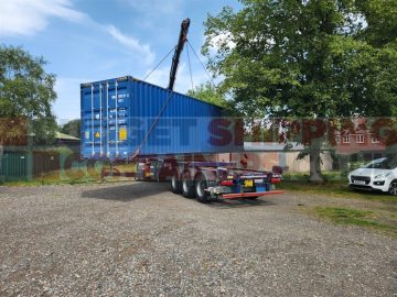 Crane lifting the container off the back of the lorry