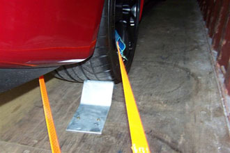Ratchet strap securing a car wheel in a shipping container